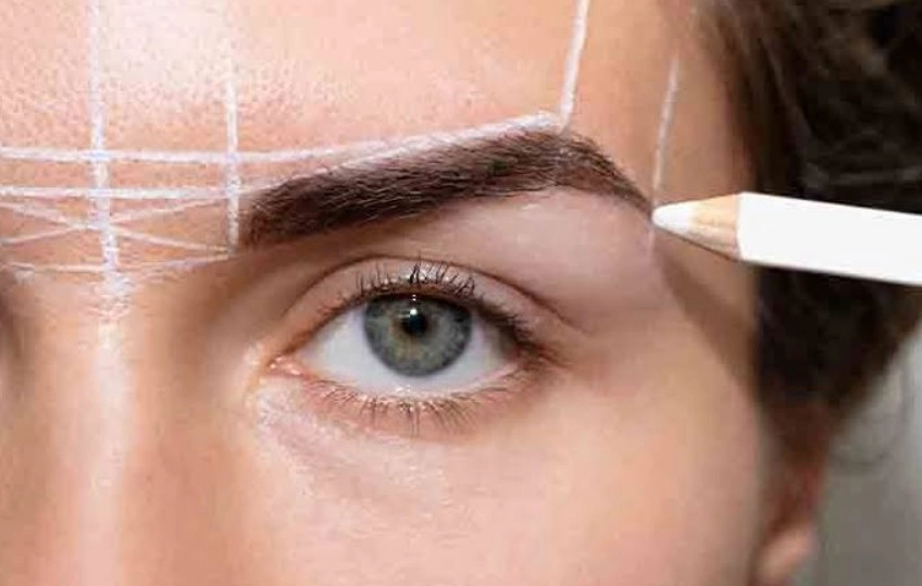 Client receiving professional eyebrow mapping and pencil shaping consultation