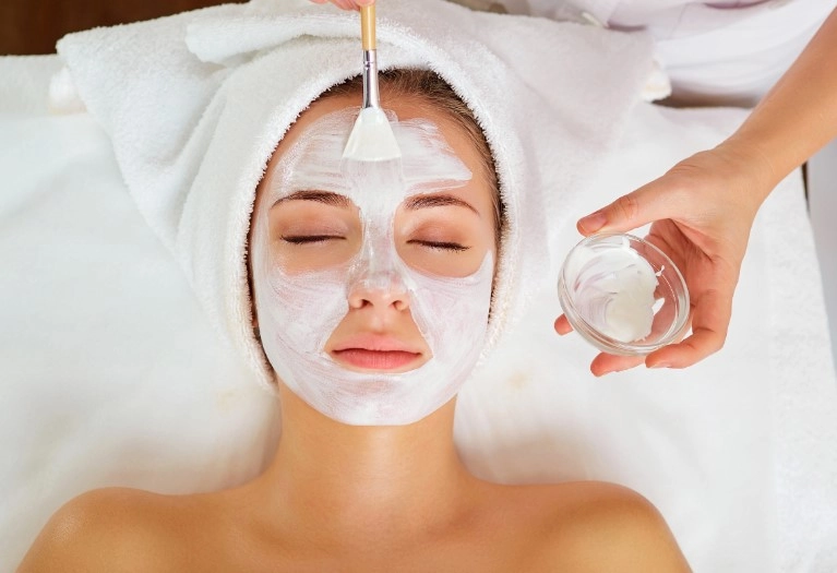 Gentle brush application of nourishing facial mask to forehead