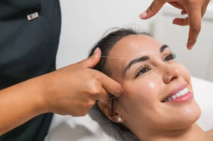 Client consulting with a threading technician before a first eyebrow threading appointment in Queens NY