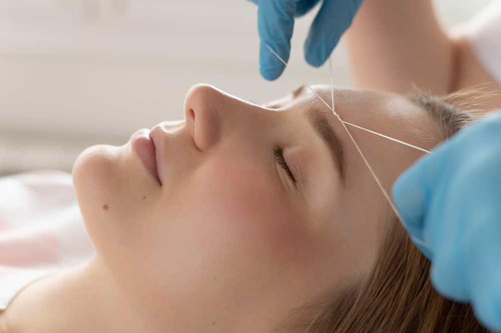 Close-up of professional eyebrow threading and shaping technique at Meena Beauty Salon, highlighting precision and care for smooth skin